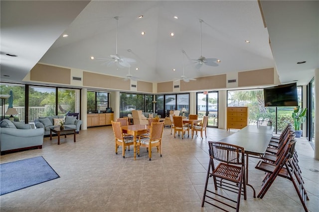 tiled dining space featuring high vaulted ceiling, a wealth of natural light, and ceiling fan