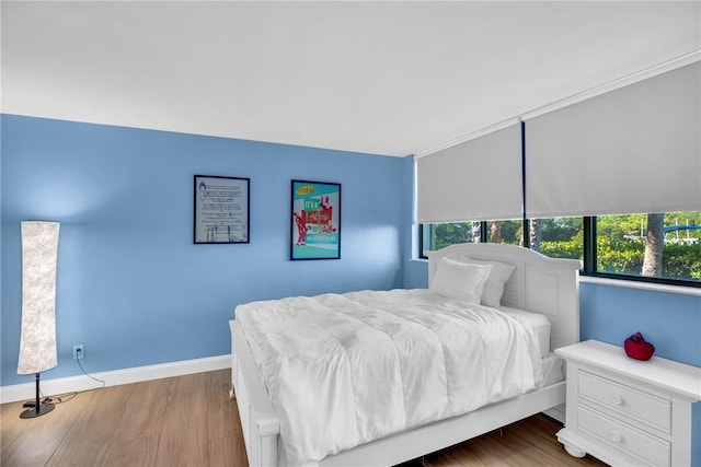 bedroom with hardwood / wood-style floors and ornamental molding