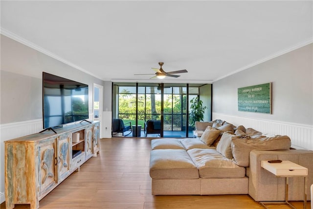 living room featuring ceiling fan, expansive windows, ornamental molding, and light hardwood / wood-style flooring