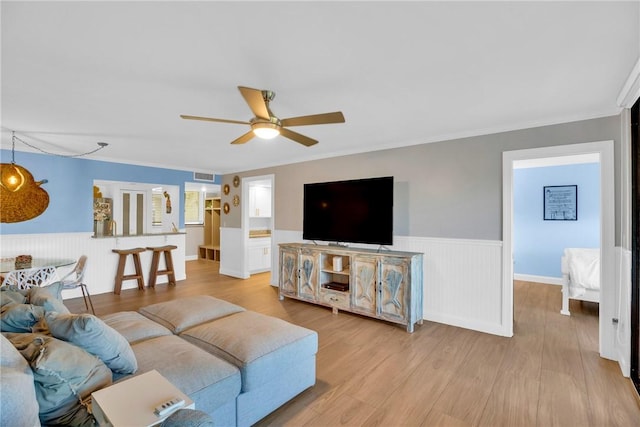 living room featuring ceiling fan, light hardwood / wood-style floors, and ornamental molding