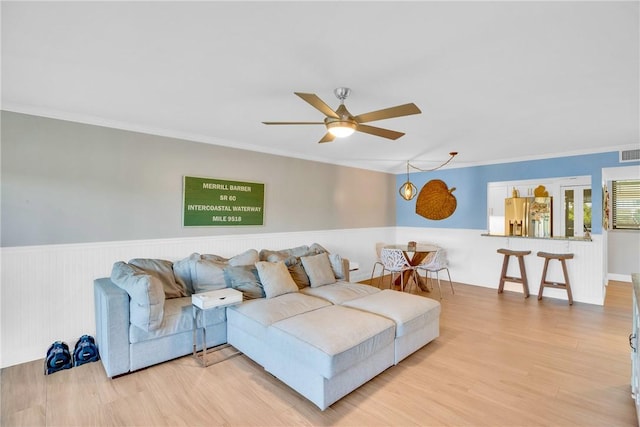 living room with ceiling fan, light hardwood / wood-style floors, and crown molding