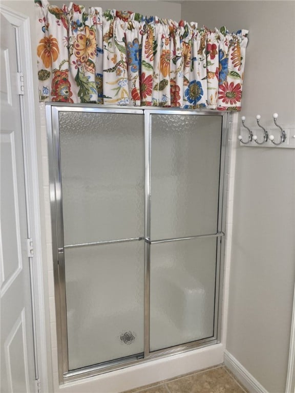 full bathroom featuring an enclosed shower and baseboards