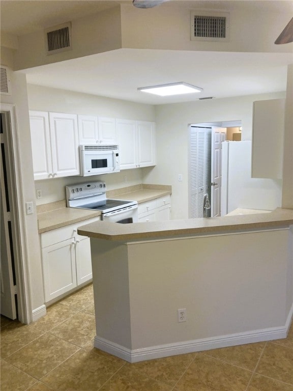 kitchen featuring visible vents, white appliances, white cabinetry, and light countertops