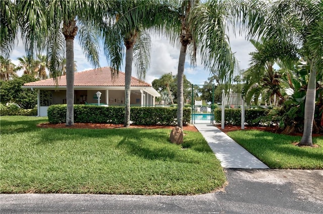 view of property's community featuring a yard, fence, and a gate