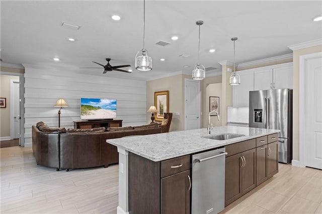 kitchen with pendant lighting, visible vents, appliances with stainless steel finishes, a sink, and an island with sink