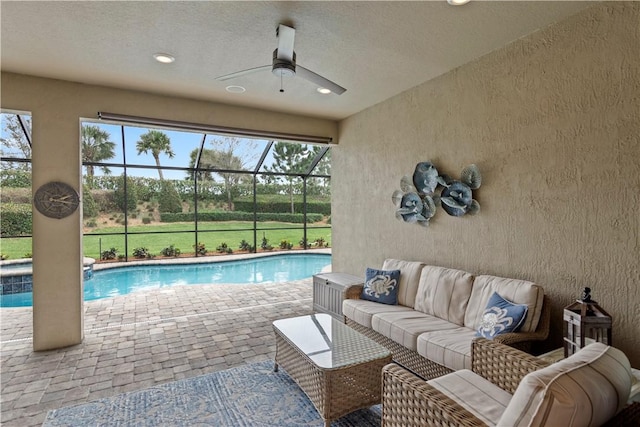 exterior space featuring a ceiling fan, a lanai, a patio area, a pool with connected hot tub, and an outdoor living space