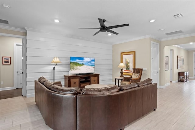 living area featuring baseboards, visible vents, a ceiling fan, and ornamental molding