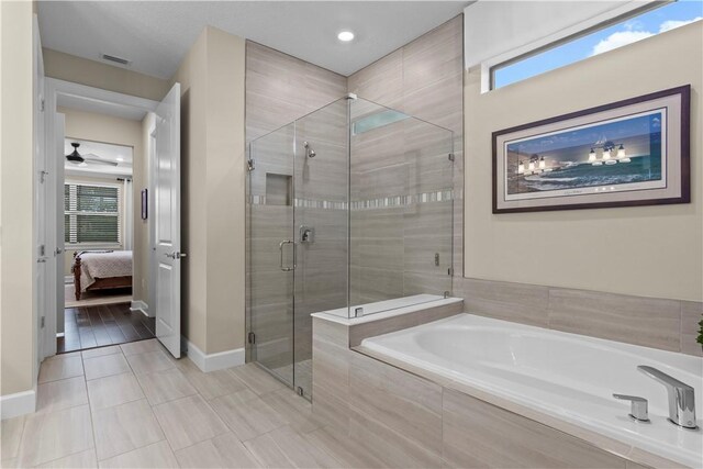 full bathroom with visible vents, baseboards, ensuite bath, a garden tub, and a shower stall