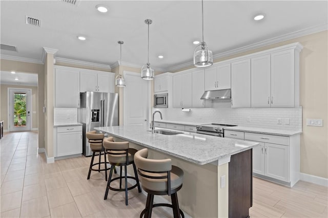 kitchen with pendant lighting, stainless steel appliances, a sink, and white cabinets