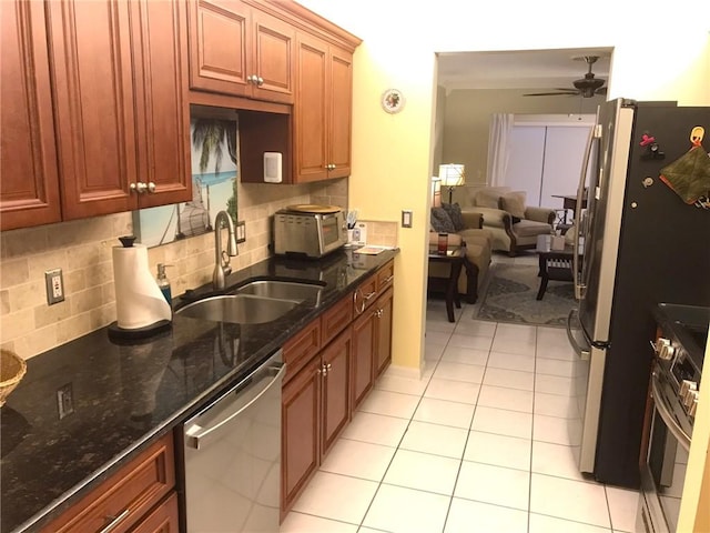 620 E Lake Jasmine Cir Unit 102, Vero Beach, FL 32962 - kitchen featuring stainless steel appliances, ceiling fan, backsplash, light tile patterned flooring, and dark stone countertops