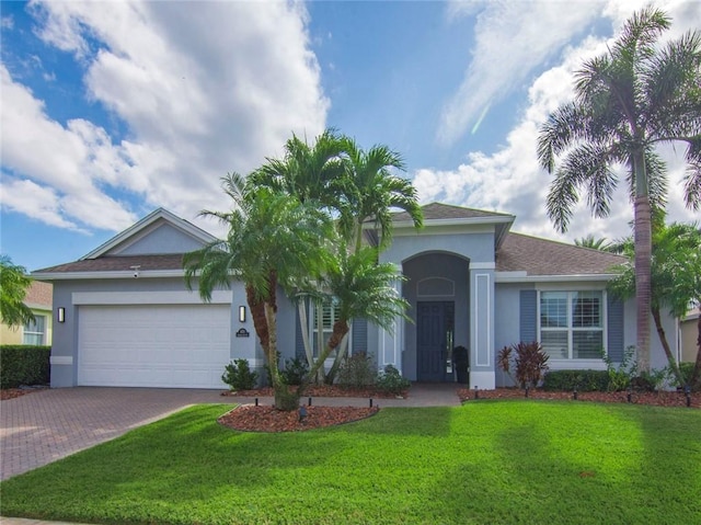 ranch-style house with a garage and a front lawn