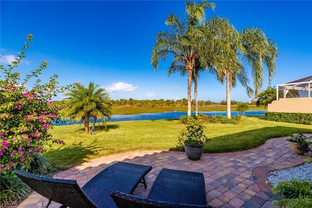 view of patio with a lanai and a water view