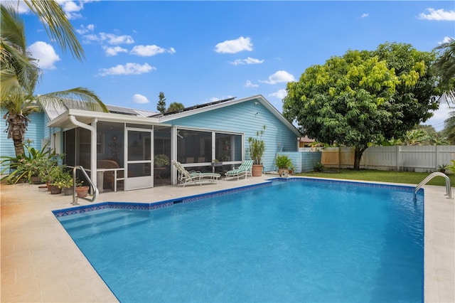 view of pool featuring a patio area and a sunroom