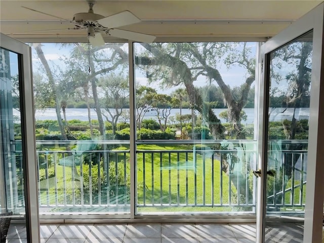 interior space with ceiling fan, a water view, and a healthy amount of sunlight