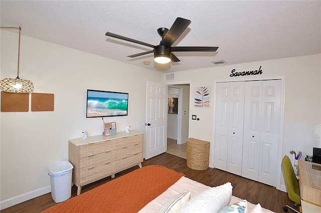 bedroom featuring a textured ceiling, dark hardwood / wood-style floors, ceiling fan, and a closet