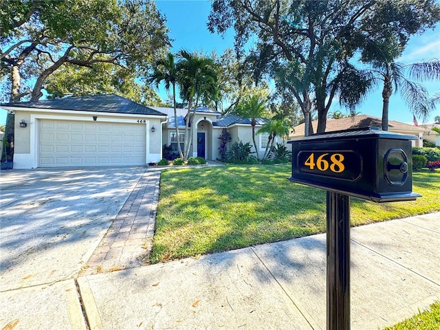 view of front of home with a garage and a front lawn