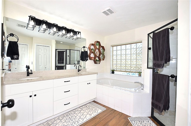 bathroom featuring hardwood / wood-style flooring, vanity, and independent shower and bath