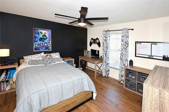 bedroom with ceiling fan, a textured ceiling, and dark hardwood / wood-style flooring