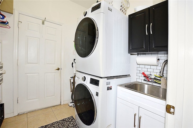 laundry room featuring cabinets, sink, stacked washer and clothes dryer, and light tile patterned floors