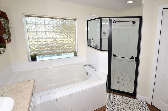 bathroom featuring hardwood / wood-style flooring, vanity, and shower with separate bathtub