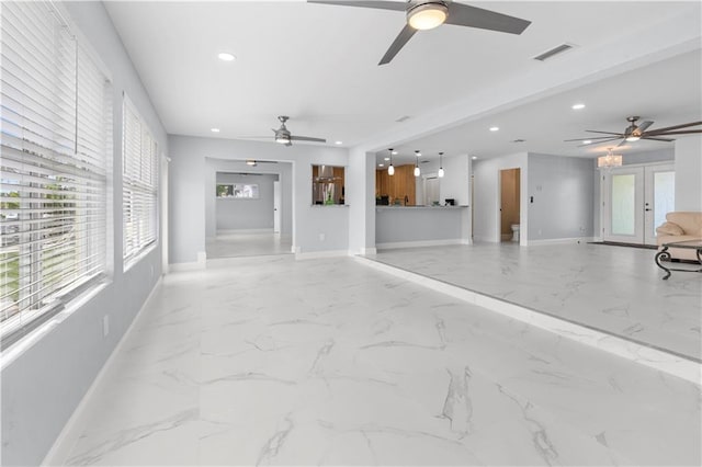 unfurnished living room featuring ceiling fan and french doors