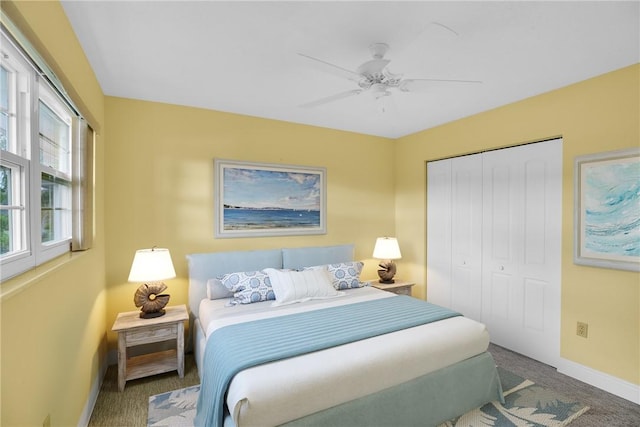 carpeted bedroom with ceiling fan and a closet