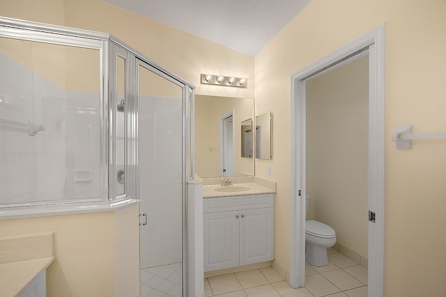 bathroom featuring walk in shower, a textured ceiling, vanity, tile patterned flooring, and toilet