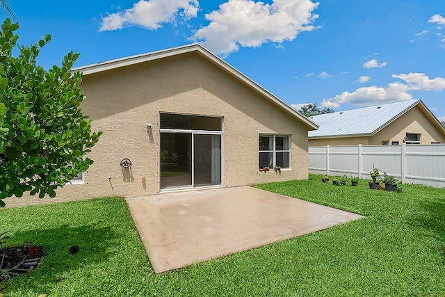 rear view of property featuring a lawn and a patio area