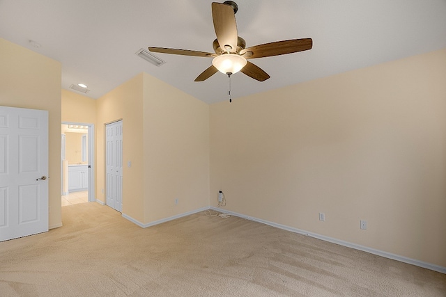 spare room featuring ceiling fan, light carpet, and lofted ceiling