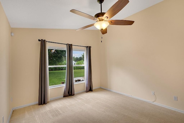 carpeted spare room featuring ceiling fan and lofted ceiling