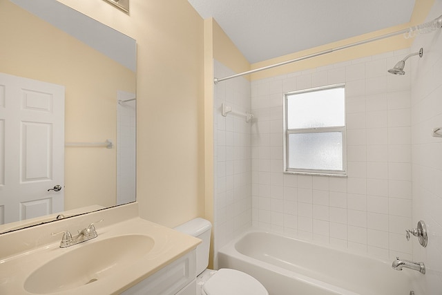 full bathroom featuring vanity, tiled shower / bath combo, and toilet