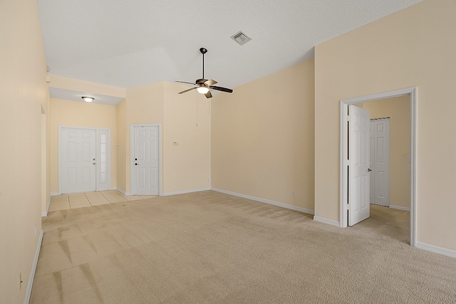 empty room featuring a textured ceiling, ceiling fan, light carpet, and high vaulted ceiling