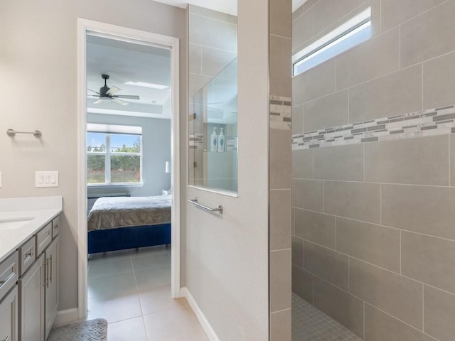 bathroom with ceiling fan, vanity, tile patterned flooring, and a tile shower