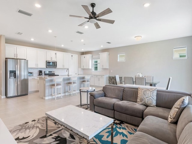 tiled living room featuring sink and ceiling fan