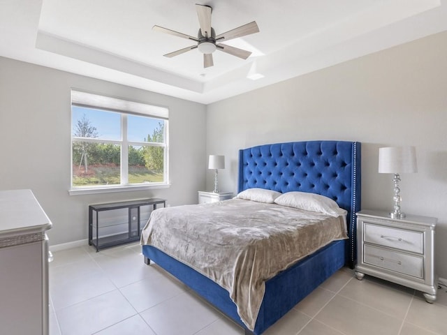 bedroom featuring light tile patterned floors, a raised ceiling, and ceiling fan