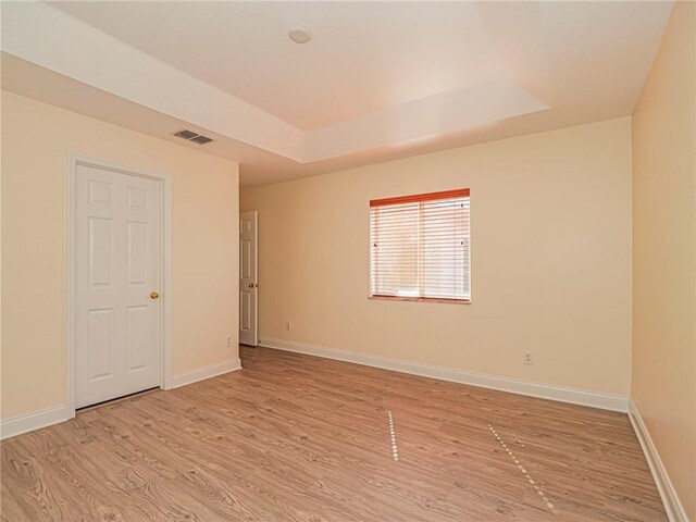 1544 Par Ct, Vero Beach, FL 32966 - unfurnished room featuring light wood-style flooring and a tray ceiling