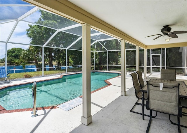 pool featuring a patio, a ceiling fan, and glass enclosure