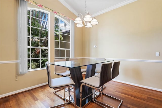 dining space with ornamental molding, baseboards, an inviting chandelier, and wood finished floors