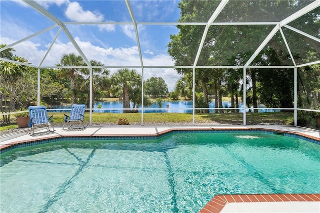 outdoor pool featuring a water view, glass enclosure, and a patio area