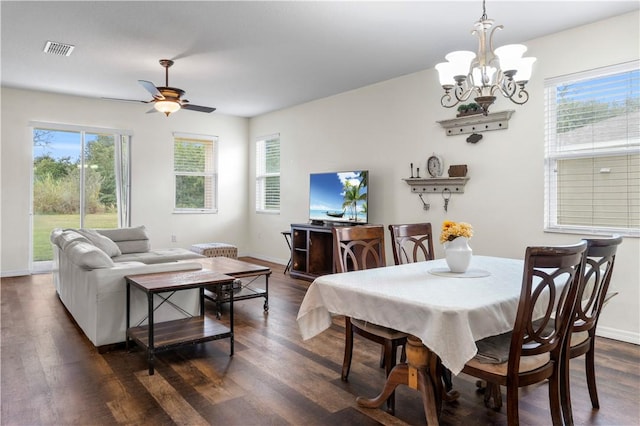 dining space featuring dark hardwood / wood-style floors, a wealth of natural light, and ceiling fan with notable chandelier