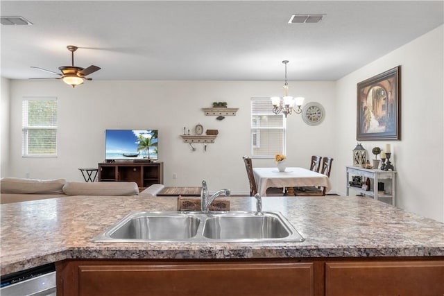 kitchen featuring pendant lighting, ceiling fan with notable chandelier, dishwasher, and sink