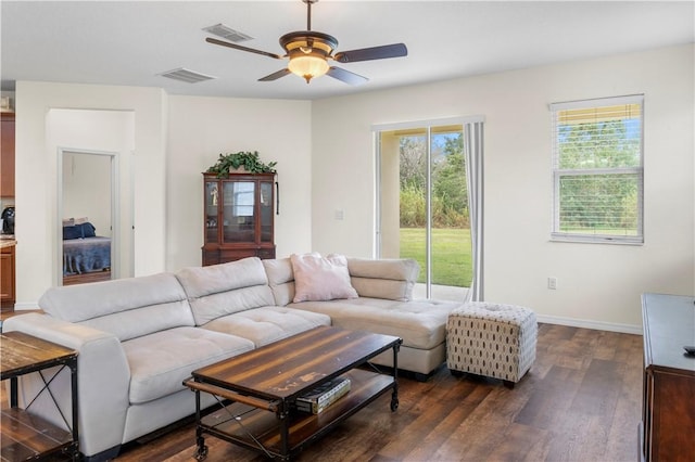 living room featuring ceiling fan and dark hardwood / wood-style floors