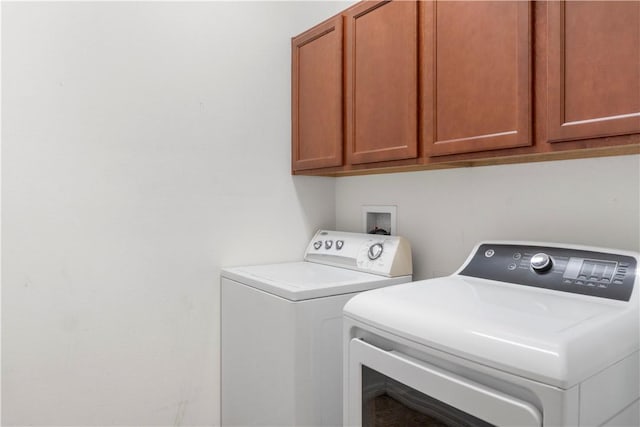 washroom with cabinets and washing machine and dryer