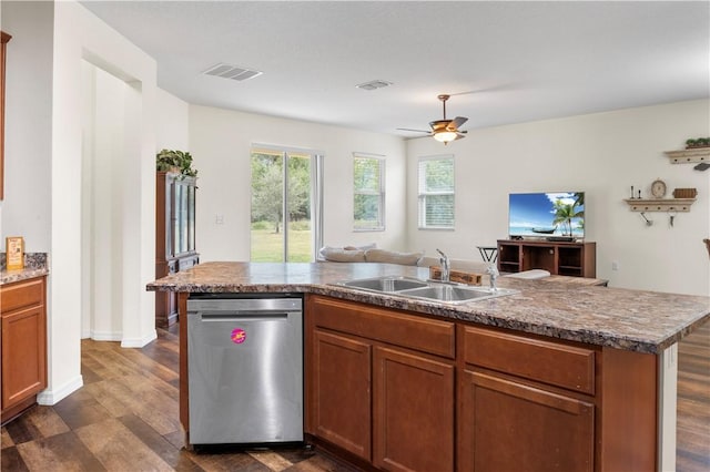 kitchen with sink, dark hardwood / wood-style floors, ceiling fan, stainless steel dishwasher, and a center island with sink