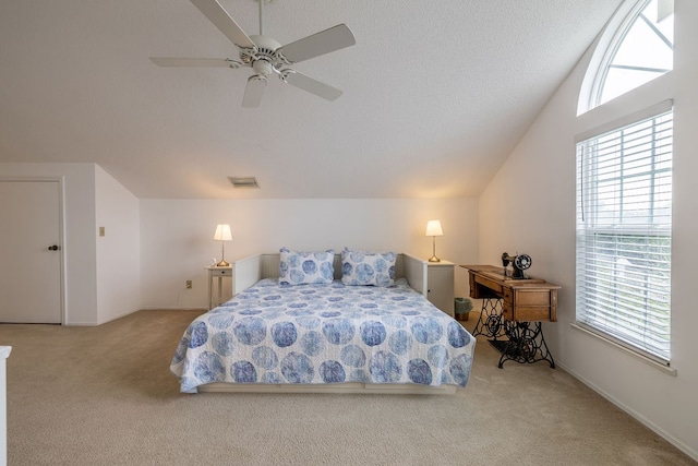 carpeted bedroom with ceiling fan, a textured ceiling, and vaulted ceiling