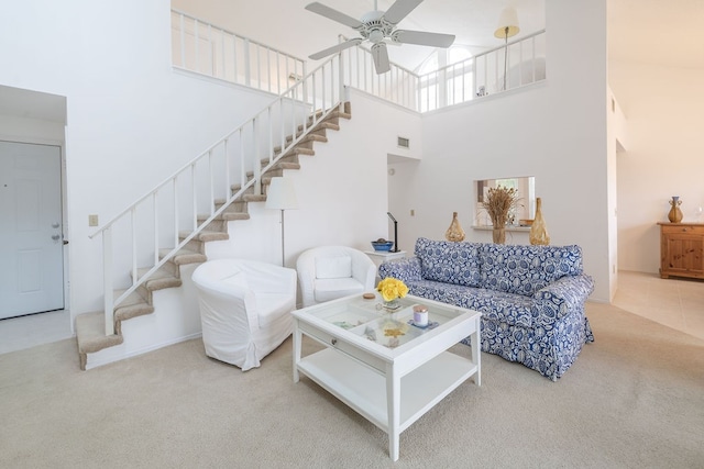 carpeted living room with a towering ceiling and ceiling fan