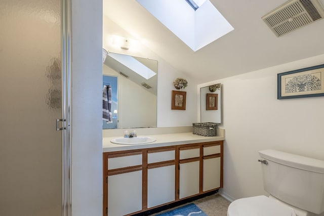 bathroom with a shower with door, tile patterned flooring, lofted ceiling with skylight, vanity, and toilet