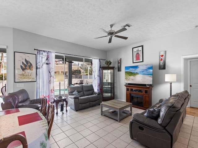 tiled living room featuring a textured ceiling and ceiling fan