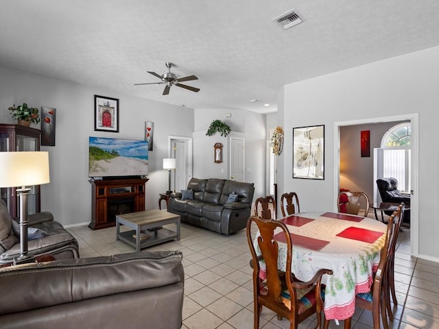 tiled dining space featuring ceiling fan and a textured ceiling