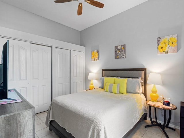 tiled bedroom featuring two closets and ceiling fan